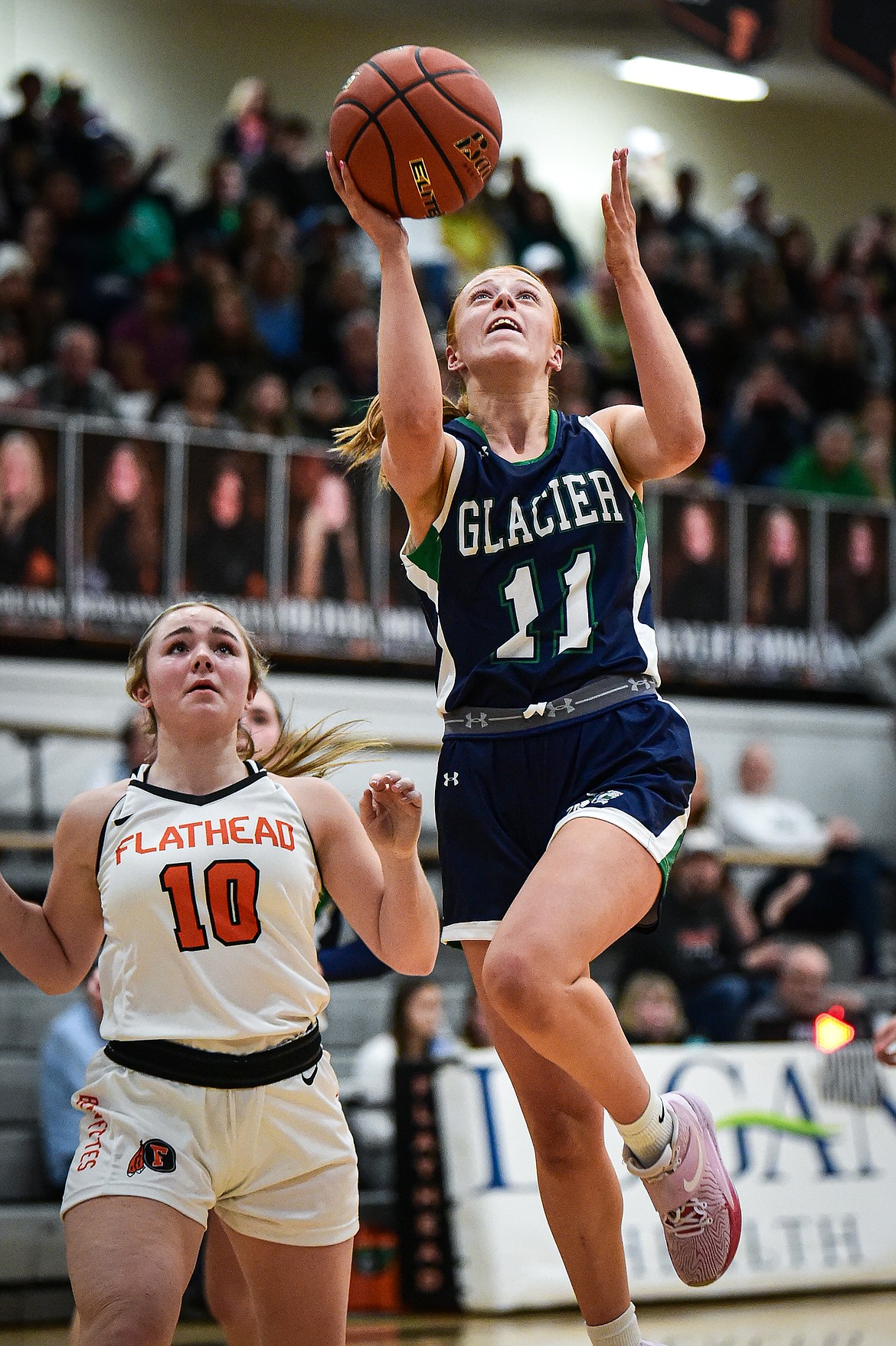 Glacier's Kenedee Moore (11) drives to the basket guarded by Flathead's Quin Tennison (10) at Flathead High School on Friday, Jan. 19. (Casey Kreider/Daily Inter Lake)