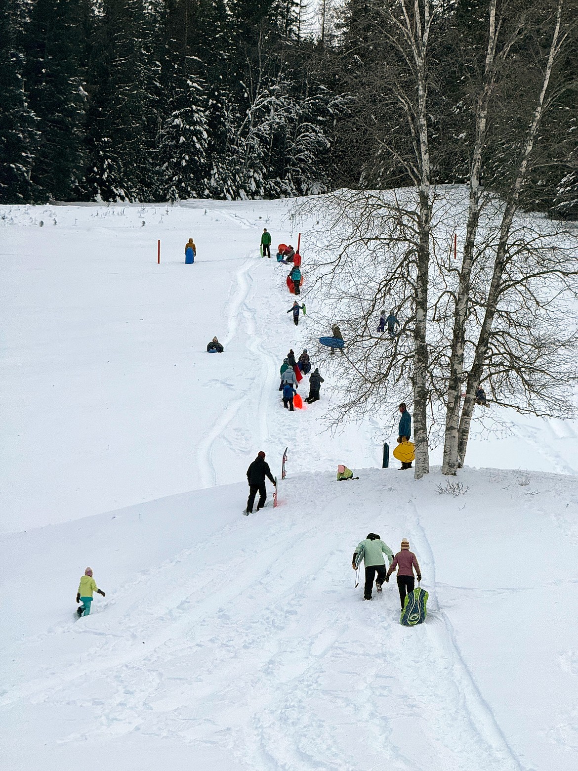 Local youths make their way up the Pine Street Sled Hill on Tuesday, Jan. 16. The sled hill reopened after the Kaniksu Land Trust purchased the 48-acre site last year after a successful community fundraising campaign.