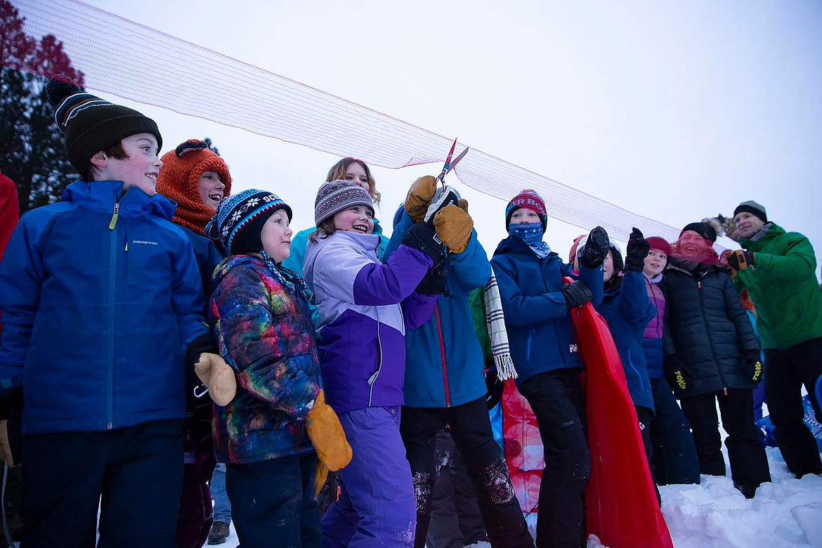 Local youth and Kaniksu Land Trust officials cut a ribbon to officially open the Pine Street Sled Hill on Tuesday, Jan. 16. The sled hill reopened after the Kaniksu Land Trust purchased the 48-acre site last year after a successful community fundraising campaign.