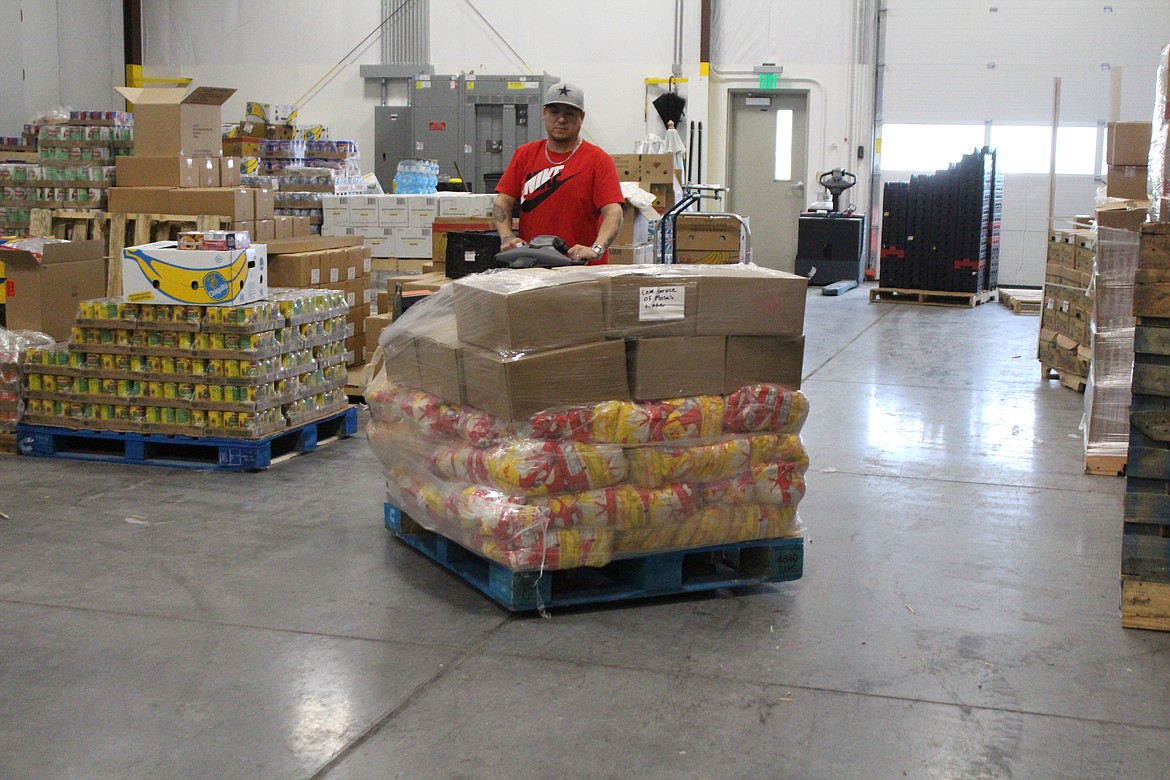 Ricky Padron, warehouse manager at the Moses Lake Food Bank, moves a pallet of food.