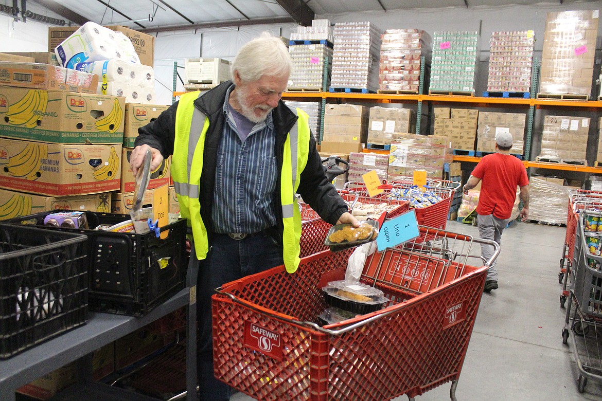 Food bank worker Terry Steinfort sorts food bank donations before distribution Monday. While donations often ramp up during the holidays, the need for food and other aid is there throughout the year.