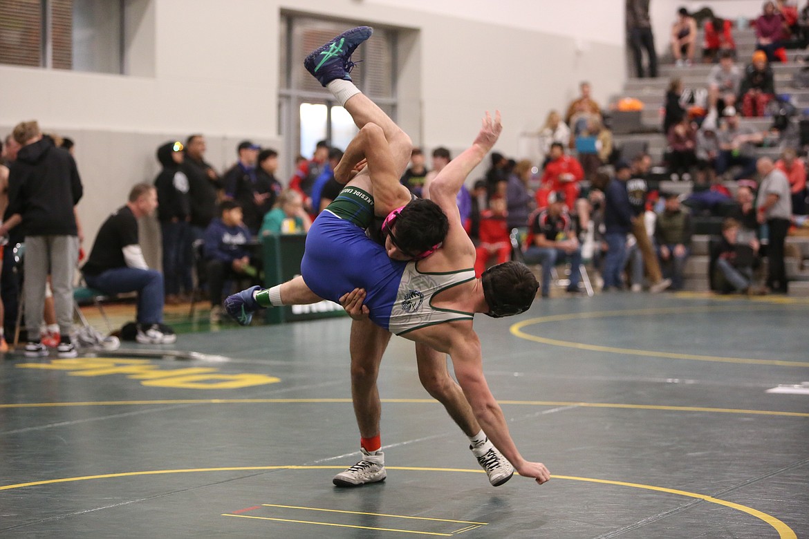 Royal sophomore Kevin Almonte, background, takes down his opponent at Saturday’s Mat Animal Invitational in Quincy.