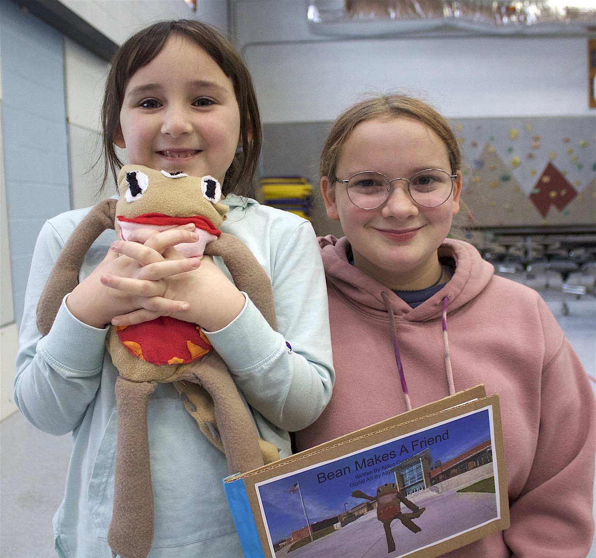 Cherry Valley first grader Elise McCurdy and Polson Middle School eighth grader Allyson Lamphere show off Elise's monster, and the story Allyson wrote titled "Bean Makes a Friend." (Tami Morrison photo)