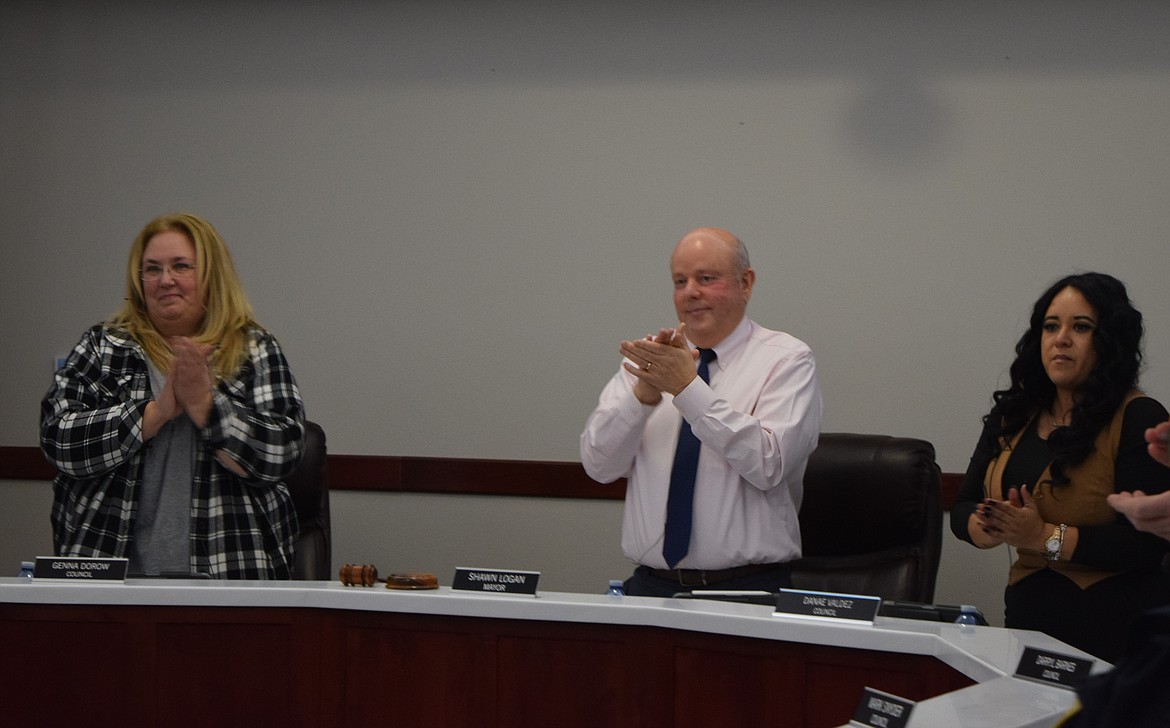 Othello City Council member Genna Dorow, left, Mayor Shawn Logan, middle, and council member Denae Valdez, right, applaud Certified Registered Nurse Anesthetists in the audience at Monday’s regular council meeting.