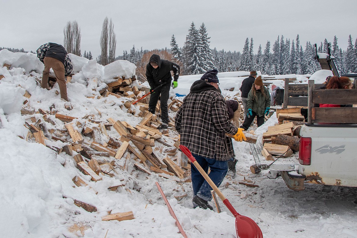 Volunteers from Eureka, Fortine and the surrounding areas help load wood into trucks for the St Michael & All Angels Wood Ministry in Fortine. (Kate Heston/Daily Inter Lake)