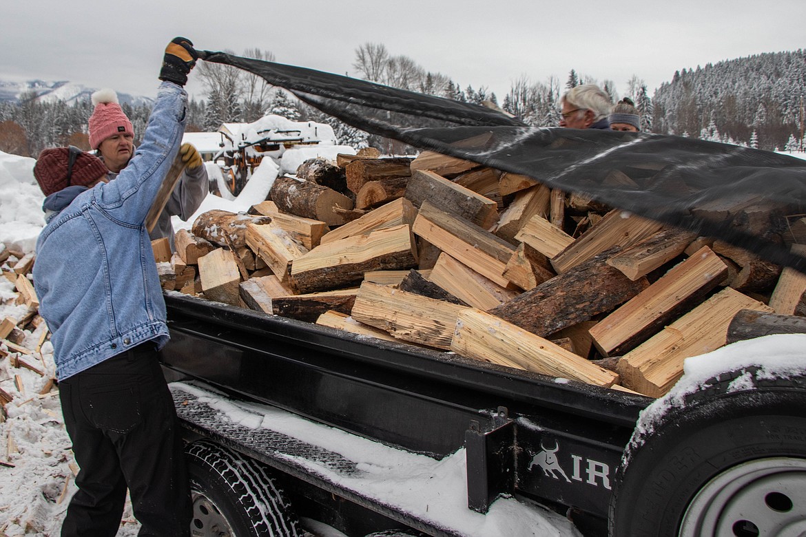 A completed load of wood gets covered for delivery at the St Michael & All Angels Wood Ministry in Fortine on Jan. 20, 2024. (Kate Heston/Daily Inter Lake)