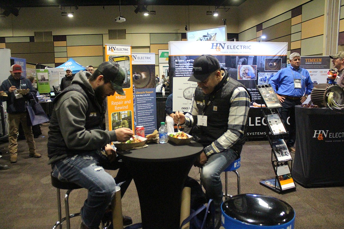 Attendees at the potato conference dig into the baked potatoes served by Washington, Oregon and Idaho potato commissioners.