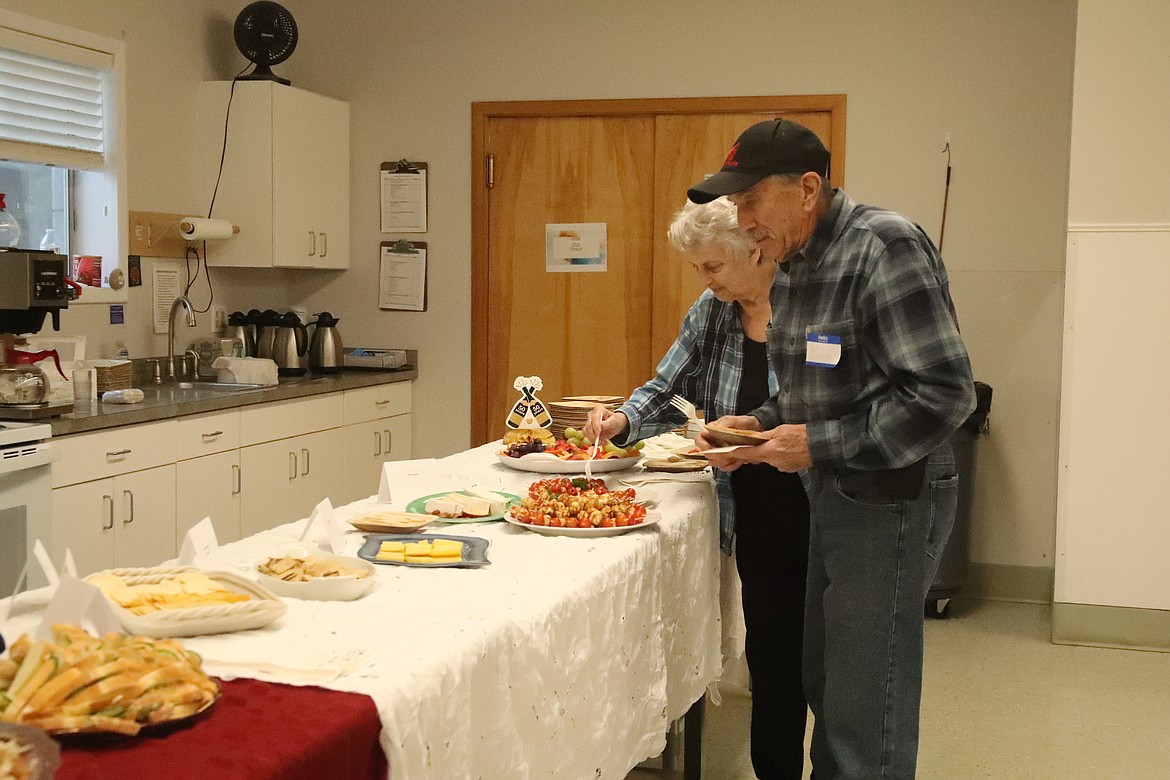 Ron Bricker and his wife examine the many choices at a buffet lunch hosted by Sandpoint Area Seniors, Inc. to celebrate the 50th anniversary of the Sandpoint Senior Center.