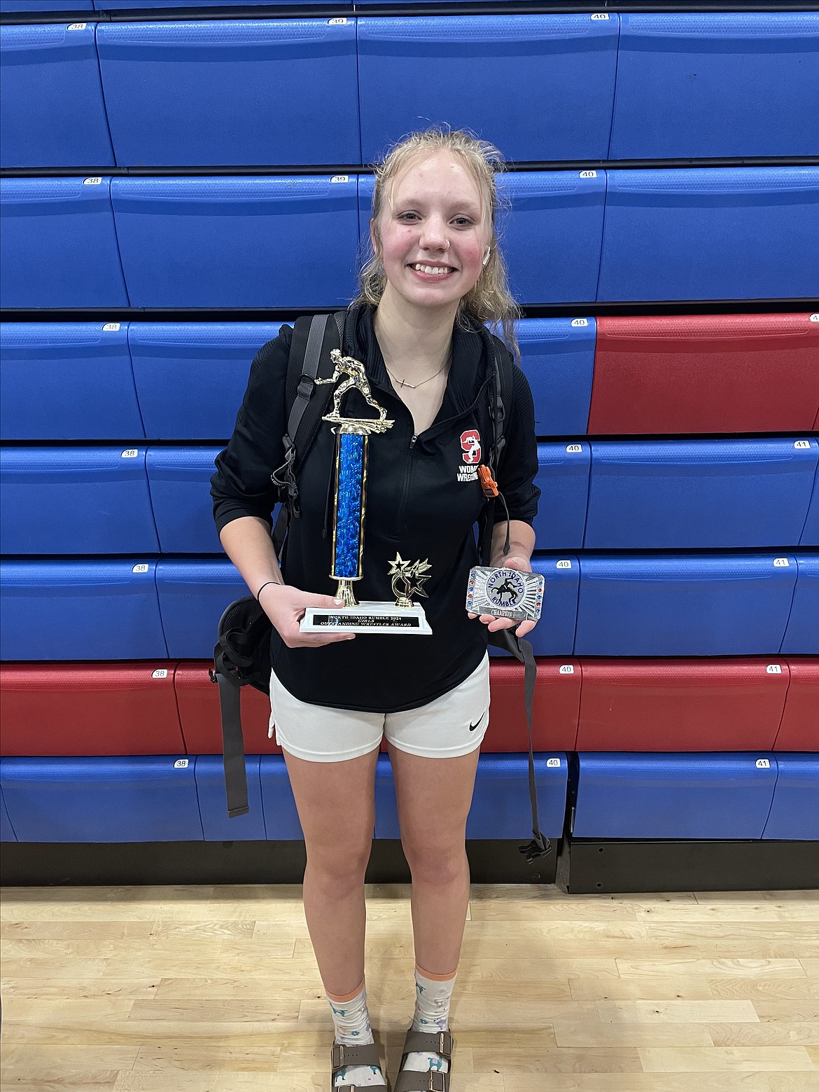 Sandpoint freshman Teagan Newsom holds up her awards from the North Idaho Rumble held at Coeur d'Alene High on Saturday. Newsom was named the tournament's most outstanding wrestler and captured an individual title after winning her weight class.