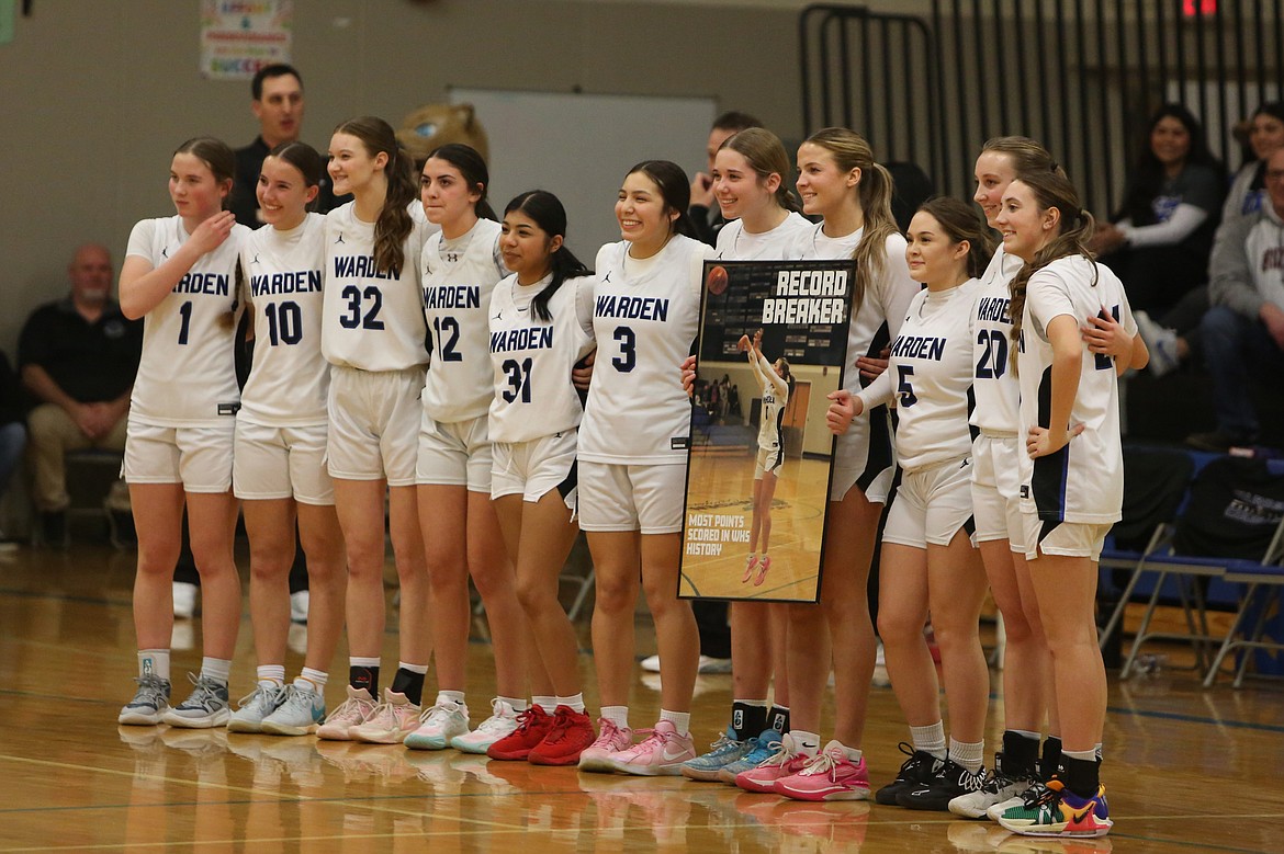 Warden players gather on the court to celebrate senior Lauryn Madsen, fourth from the right, becoming the program’s all-time leading scorer.