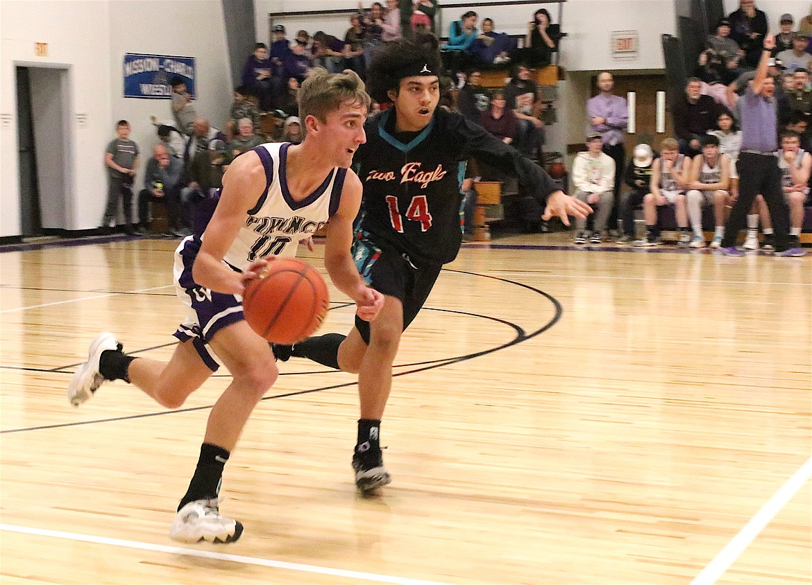 Charlo's Hayden Hollow and Two Eagle's Jayvian Burke streak down the floor during last week's Western 14C matchup in Charlo. (Michelle Sharbono photo)