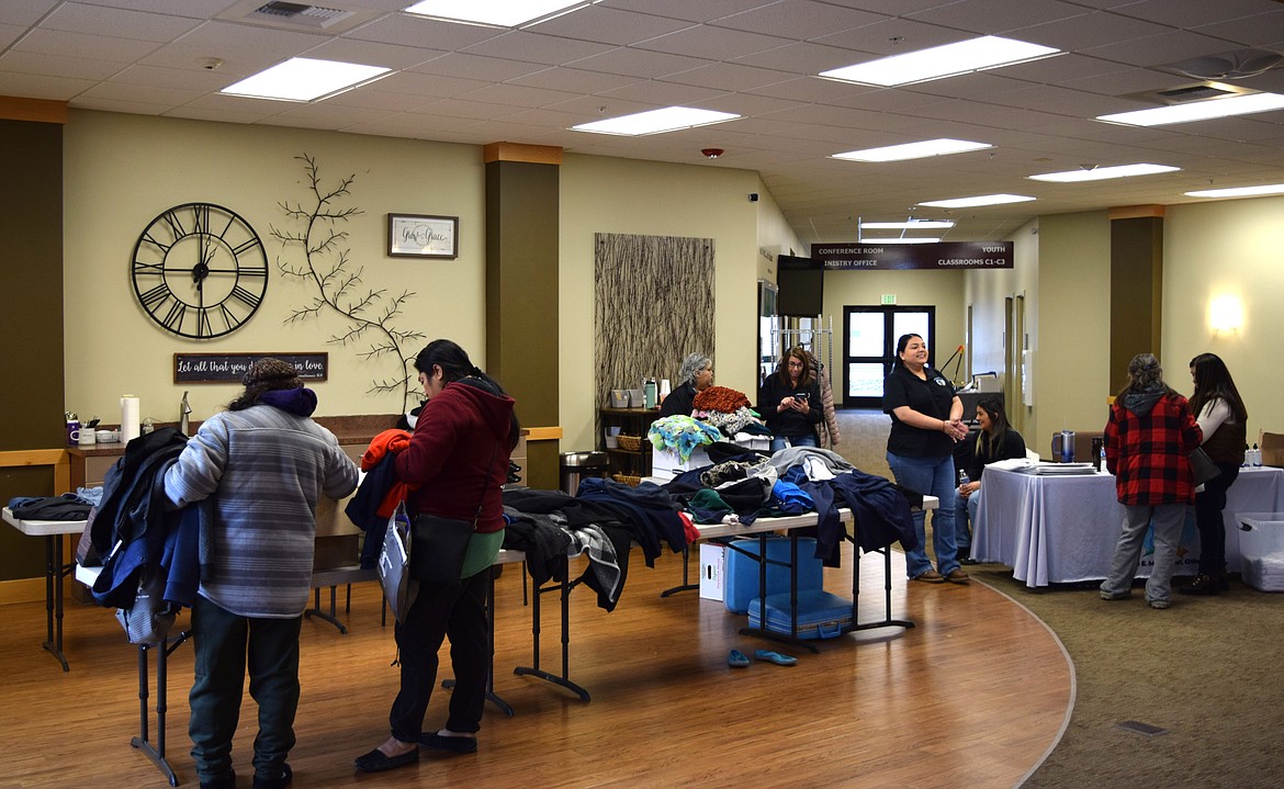 Othello community members look through supplies and clothing available at Thursday’s Othello Matters outreach event while Adams County Integrated Health Care Services staff wait to assist people at the event.