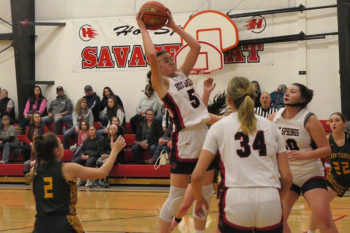 Hot Springs guard Kara Christensen goes high to snare a rebound while St. Regis' Shylah Dalke (2, green), and teammates Lauryn Aldridge and Erica Cannon look on. (Chuck Bandel/VP-MI)