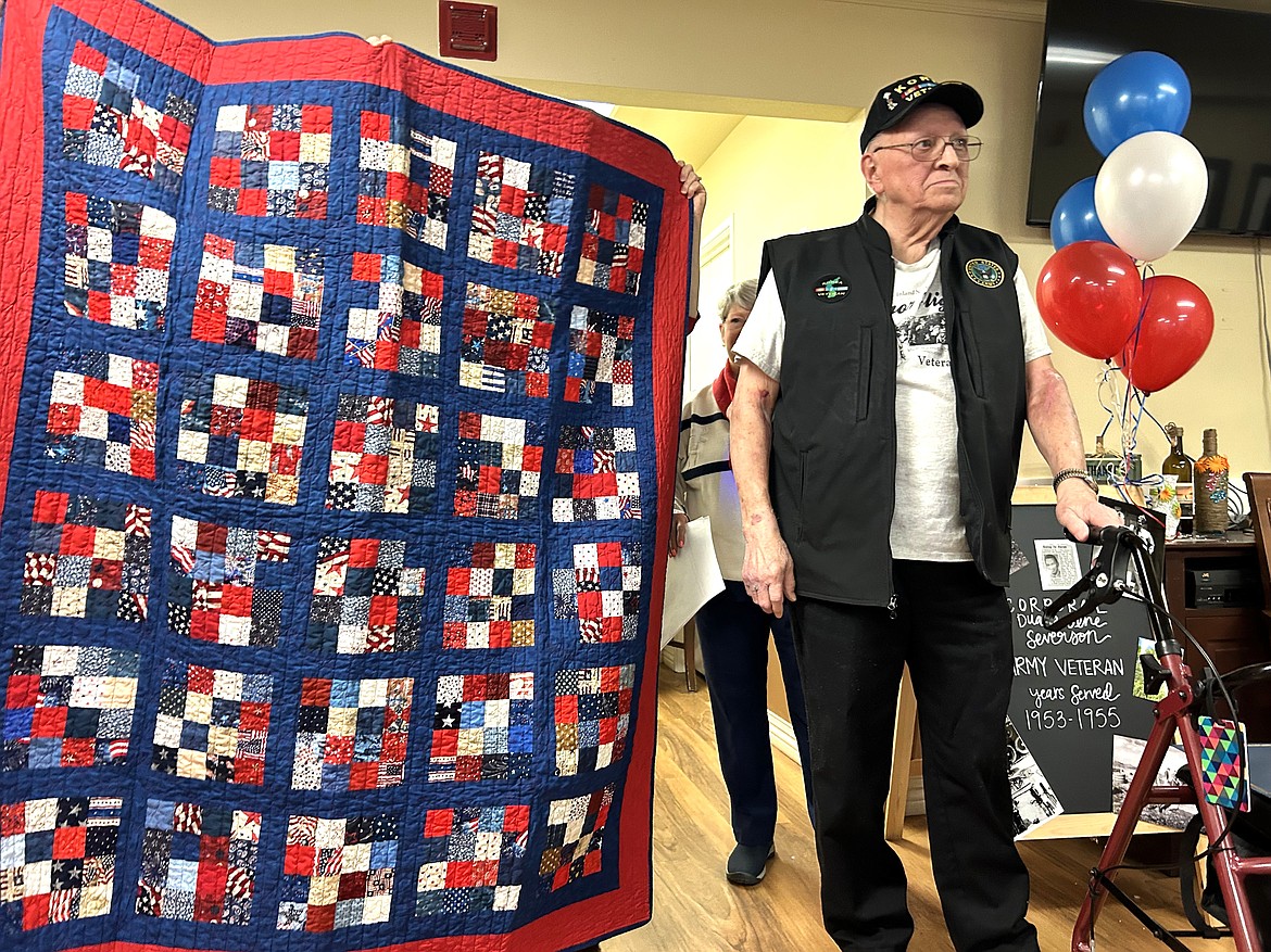 Duane Severson stands next to the quilt he received at Brookdale Coeur d'Alene on Saturday for his military service.