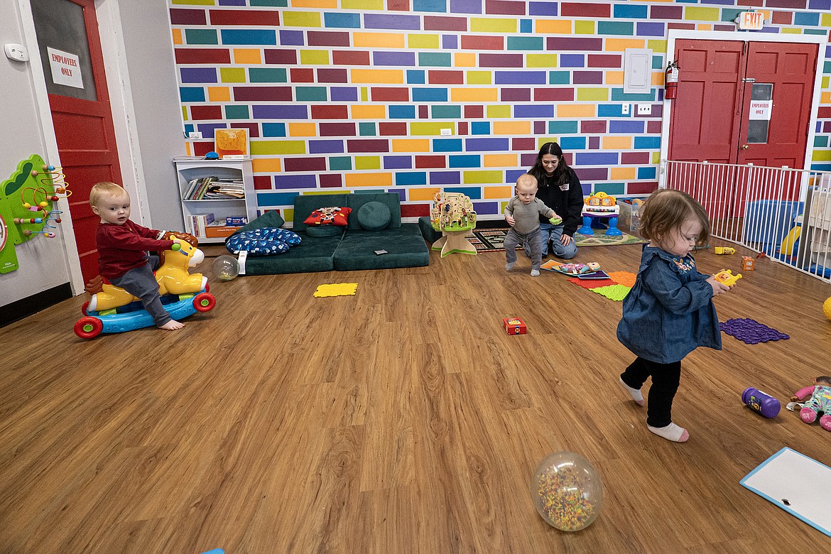 Cedric Hanson, Remi Peterson and Rylee Frazin play with Kids Corral employee Paloma Rader (back) on Monday, Jan. 22. (Avery Howe photo)