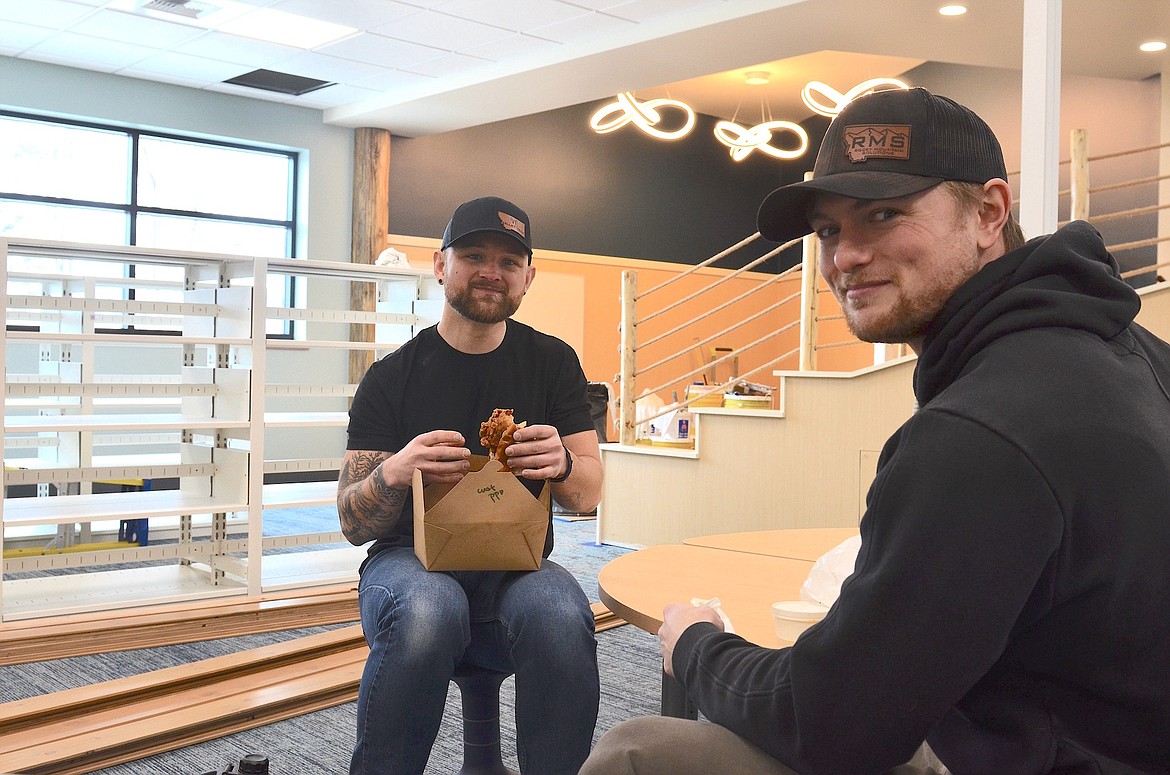 Grownups Aaron Whitsell and Trevor Klehof Valley Tech ate lunch at the kids' table in the renovated North Lake County Library last Friday before continuing to install internet and phone cables. (Kristi Niemeyer/Leader)