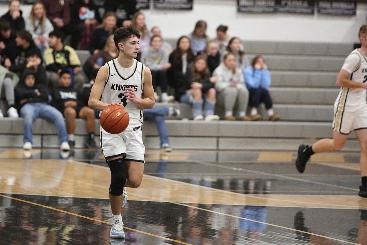 Royal junior Ezra Jenks dribbles the ball up the floor.