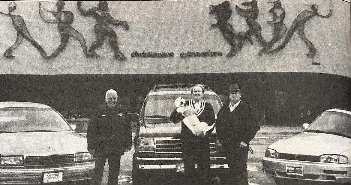 Car dealers, from left, Wayne Knudtsen, Tom Addis and Doug Parker promote the car choices for the second prize winner in the 1994 North Idaho College Foundation Really Big Raffle. Addis is holding Parker’s prized bull terrier, Yota.
