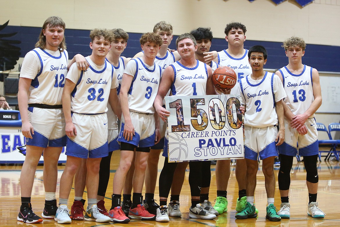 Soap Lake boys basketball players gather on the court during a timeout to celebrate senior Pavlo Stoyan (1) scoring his 1,500th career point