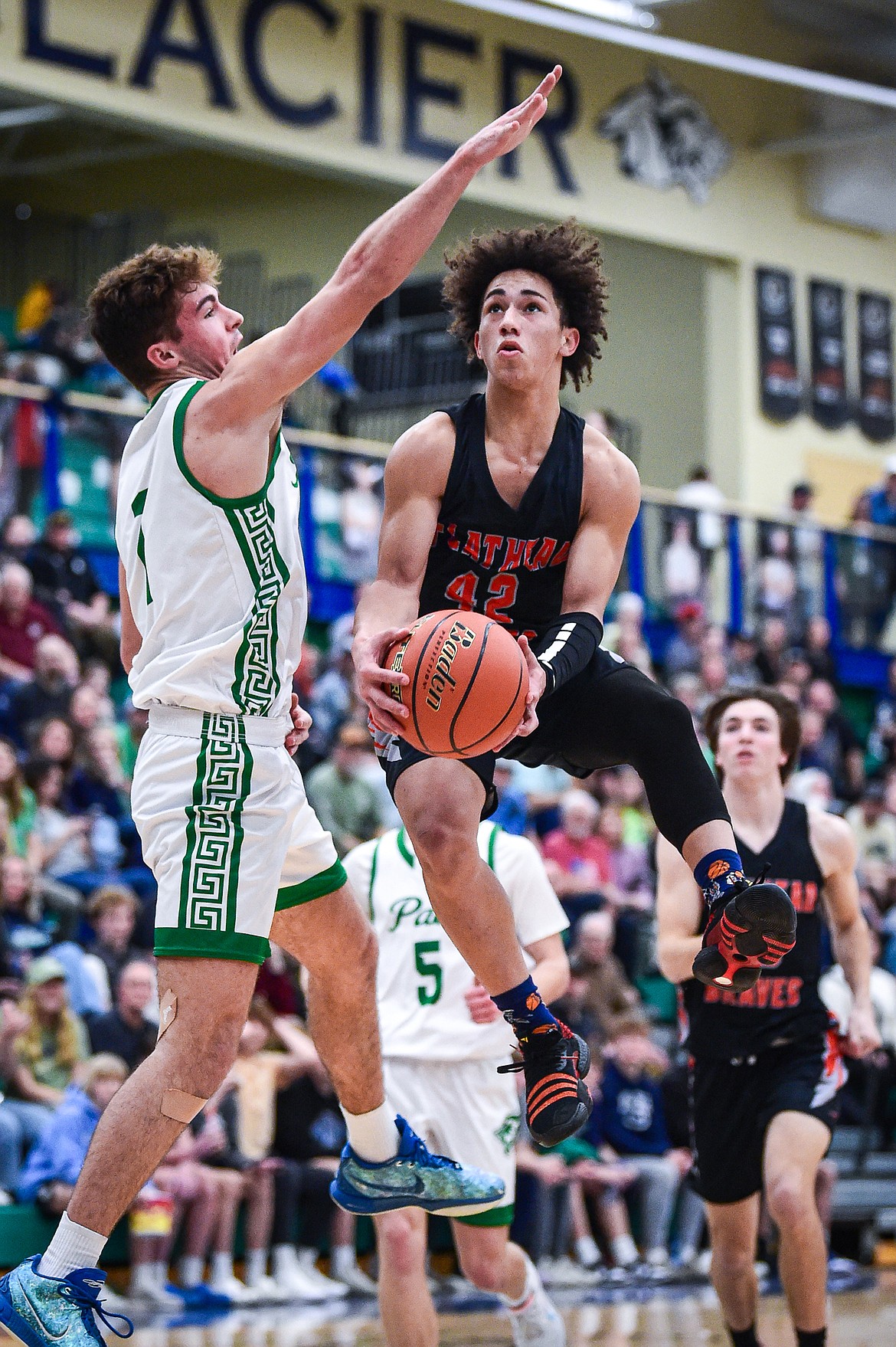 Flathead's Jordan Griffin (42) drives to the basket guarded by Glacier's Cohen Kastelitz (1) in the second half at Glacier High School on Thursday, Feb. 1. (Casey Kreider/Daily Inter Lake)