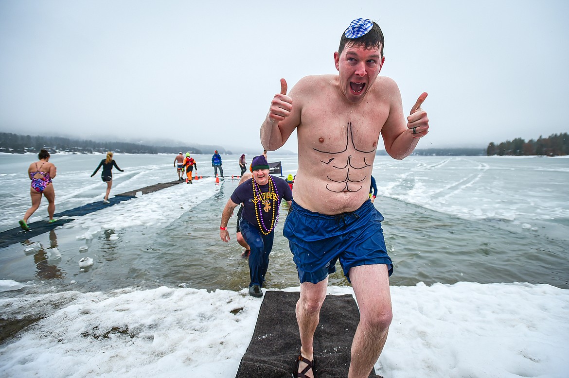 Participants step out of Whitefish Lake at the Penguin Plunge at City Beach in Whitefish on Saturday, Feb. 3. Organized by the Law Enforcement Torch Run, as part of the Whitefish Winter Carnival, the event raises money for Special Olympics Montana. (Casey Kreider/Daily Inter Lake)