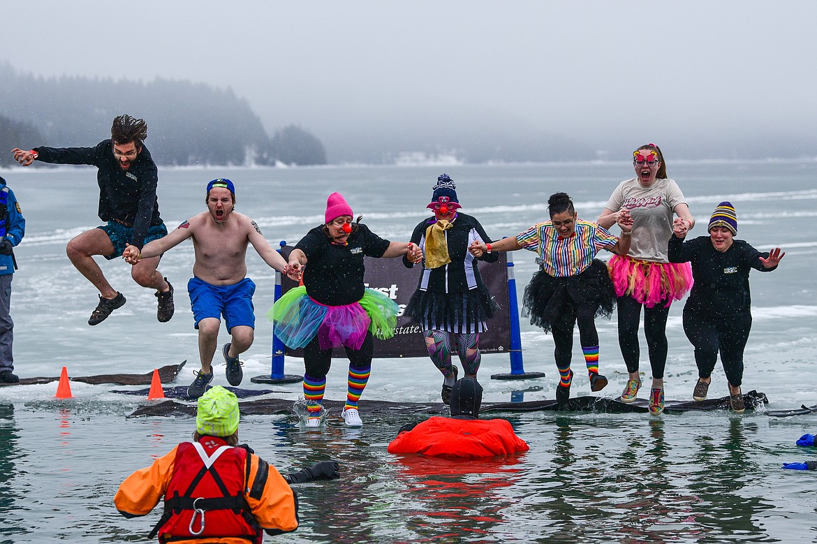Participants jump into Whitefish Lake at the Penguin Plunge at City Beach in Whitefish on Saturday, Feb. 3. Organized by the Law Enforcement Torch Run, as part of the Whitefish Winter Carnival, the event raises money for Special Olympics Montana. (Casey Kreider/Daily Inter Lake)