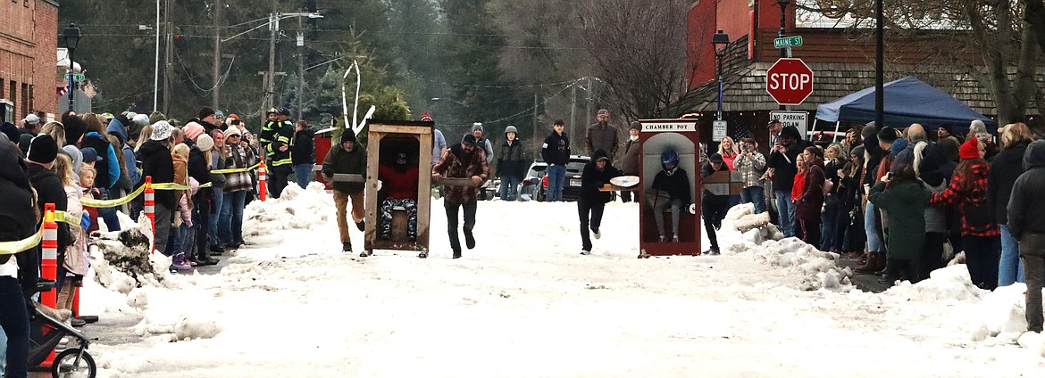 Teams head down the course in Spirit Lake Winterfest Outhouse Races on Saturday.