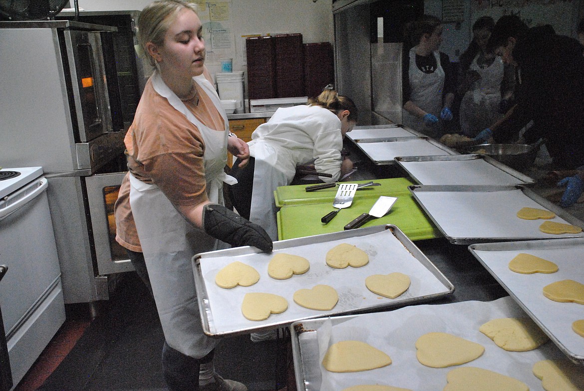 Senior, Brooke Filek, removes a hot tray of sugar cookies from the oven as the St. Regis Business Professionals chapter baked hundreds of cookies for their annual fundraiser last weekend. (Mineral Independent/Amy Quinlivan)