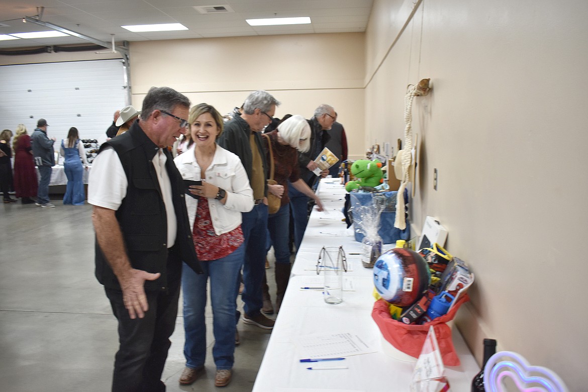 Bob Murphy, left, and Maribel Vela look over silent auction items at the Country Sweethearts Benefit Auction Saturday.