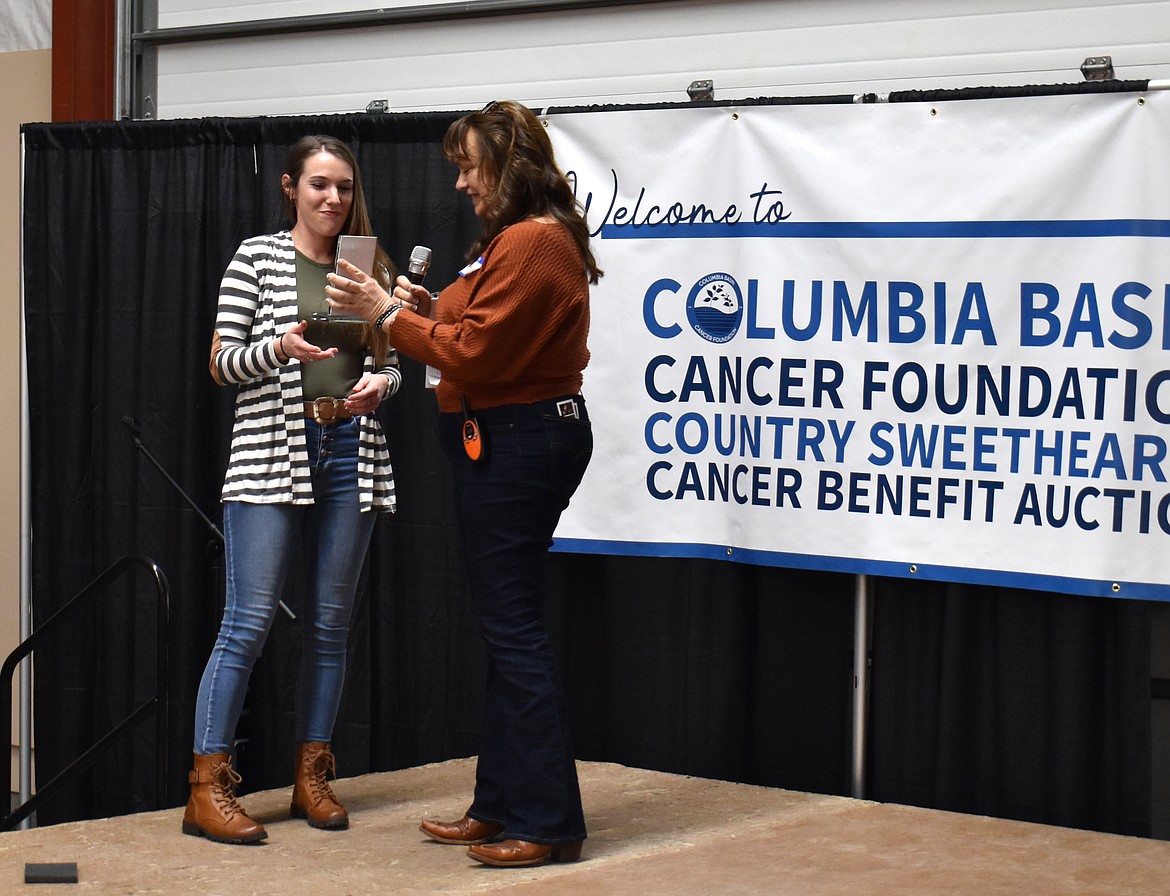 Angel Ledesma, right, presents Kelsie Eddie of Moses Lake with the Community Hero Award on behalf of the Columbia Basin Cancer Foundation. Eddie originated the annual Turkey Trot fun run 14 years ago as a fundraiser for the foundation, and has raised more than $125,000 through it.