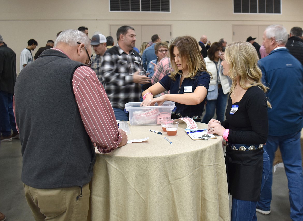 Haley Sell, left, and Amanda Carpenter sell raffle tickets at the Columbia Basin Cancer Foundation’s 15th annual Country Sweethearts Benefit Auction Saturday.