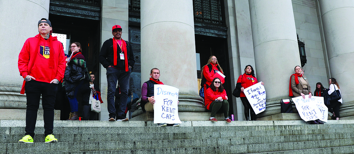 Protestors gather at the top of the Capitol's North steps, among them Vancouver residents Jeremy Hopkins of SeaMar Community Health Services and Duana Johnson from Washington Low Income Housing Alliance.