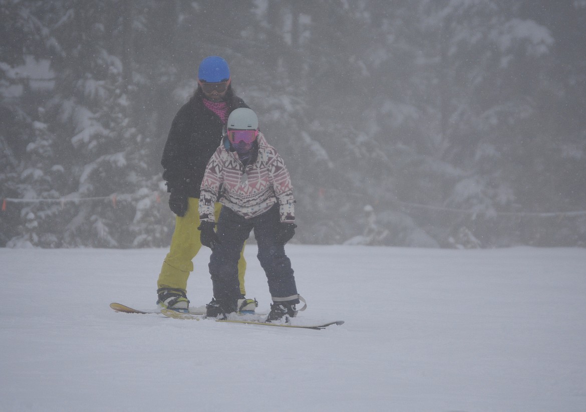 The snow was falling fast on the mountain as Matt Marche coached Vanessa Marche on snowboarding down the mountain. Vanessa works in the legal department and Matt works on weather forecasting at Fairchild Air Force Base.