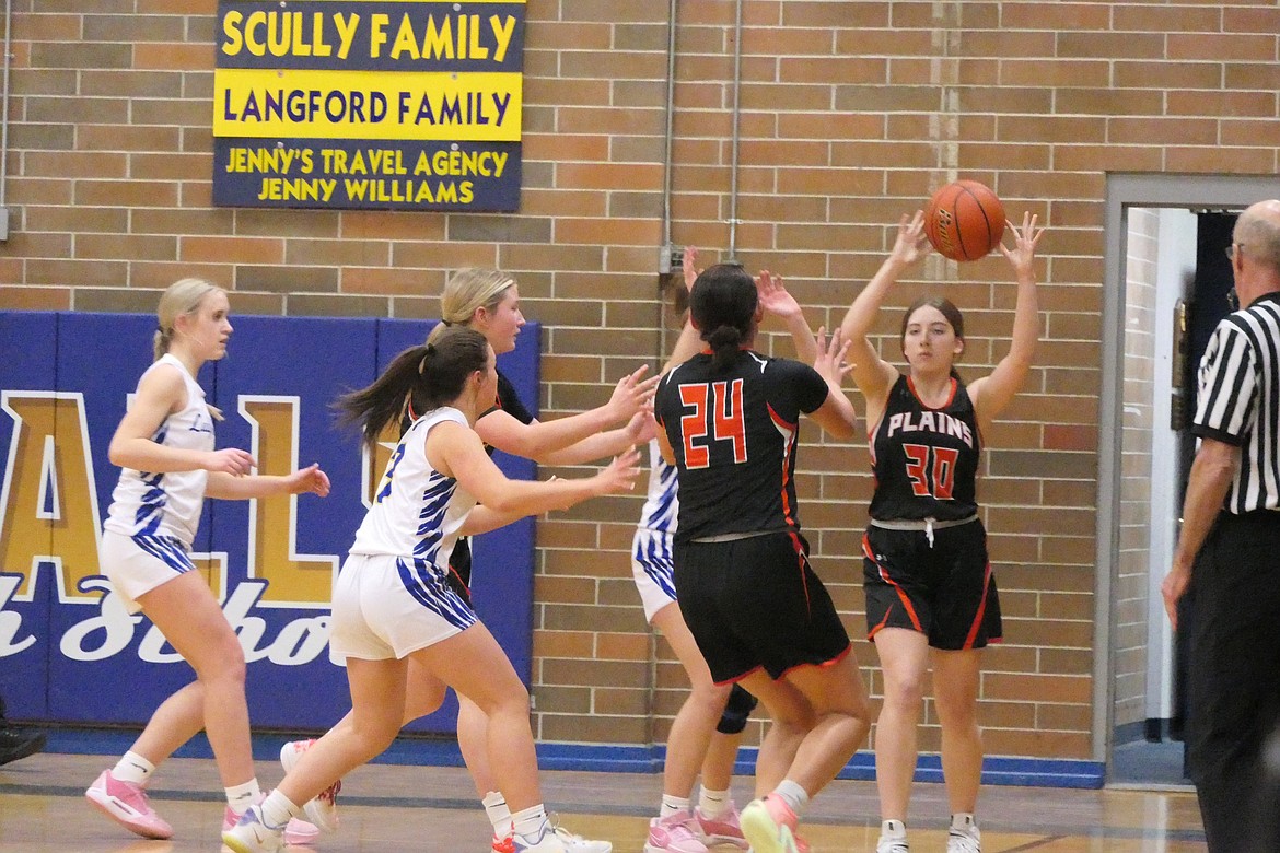 Plains' Tristan Larson (30) sends a pass to teammate Katelyn Subatch (24) during their game against Thompson Falls Thursday night in Thompson Falls. (Chuck Bandel/VP-MI)