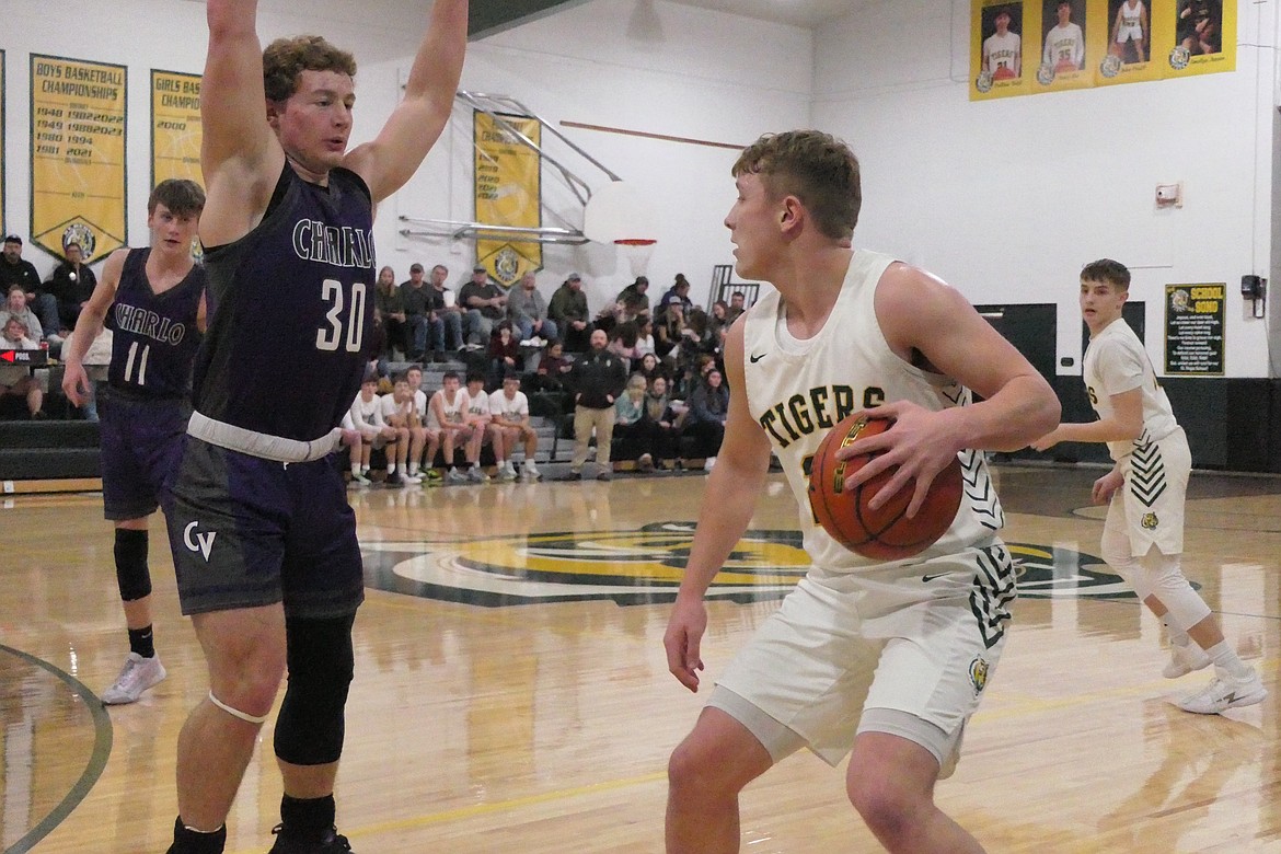 St. Regis senior forward John Pruitt (with ball) looks for a path around Charlo forward Jacob Tomlin during their game Friday night in St. Regis.  (Chuck Bandel/Mi-VP)