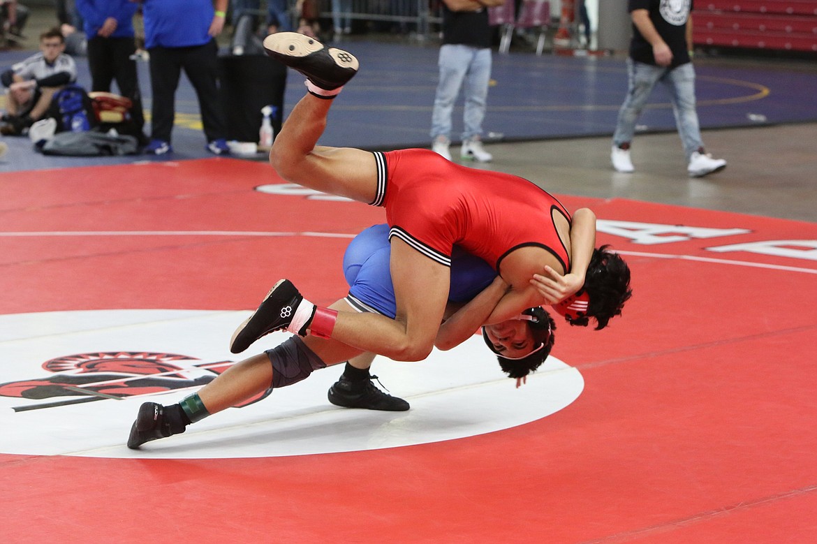 Warden junior Junior Santiago, in blue, takes down his opponent in the 138-pound finals of Friday’s Eastern Washington Athletic Conference district tournament in Yakima.