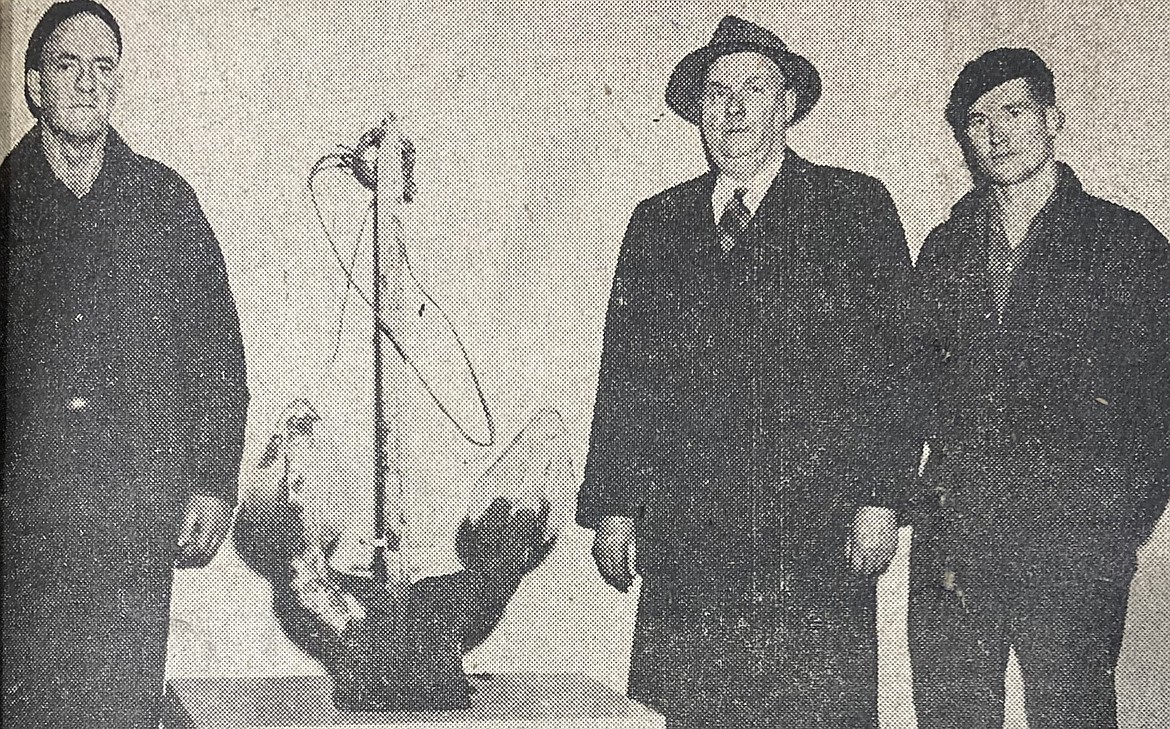 Diver Colin O’Donnell of Spokane, left, found a seaplane anchor in 112 feet of water that tore intake lines. He is shown with water superintendent Oscar Hill of Washington Water Power, center, and diver tender David Dilworth of Spokane.