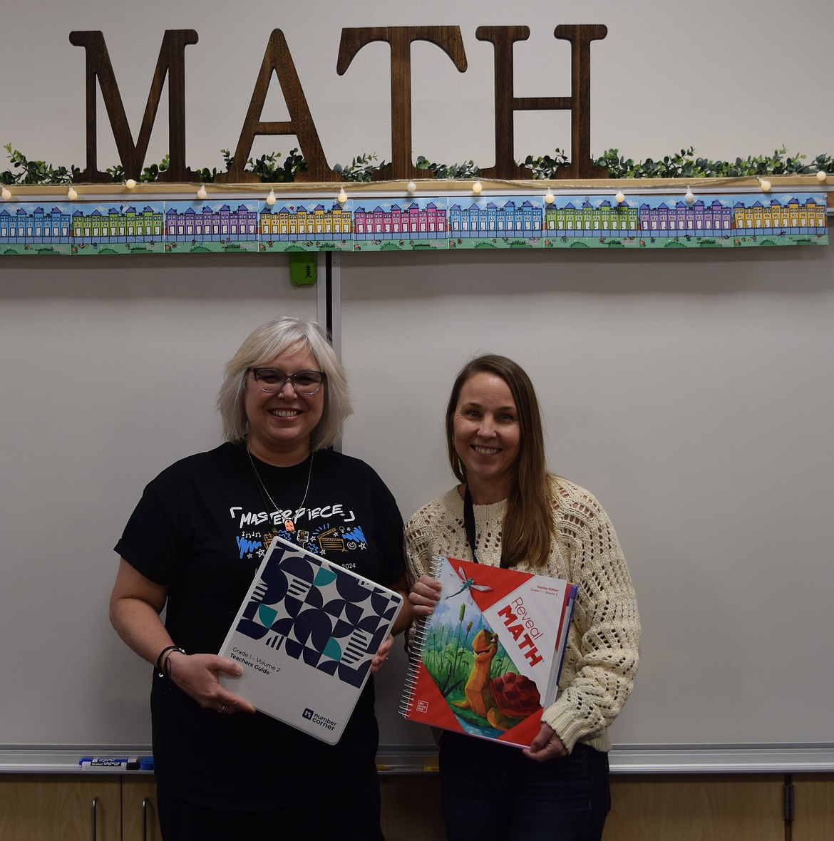 Columbia Ridge first grade teacher Julie Kessel, left, and math interventionist Jamie Andrus pose for a photo with the two sets of math materials the Eprhata School District is considering for kindergarten through fifth grade students. The two educators said each has benefits and no decision on which will be adopted has been made.