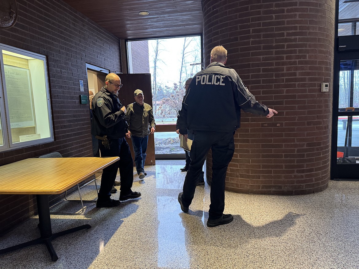 Dave Bowman is escorted out of the Bonner County Board of County Commissioners' weekly business meeting after attending the meeting despite being trespassed from the county admin building for a year.