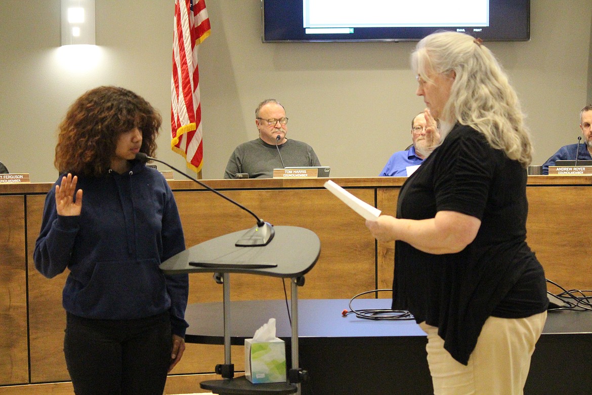 Quincy High School student Xadany Roque, left, takes the oath of office as a student representative for the Quincy City Council at the regular council meeting Tuesday. City Finance Officer/Clerk Nancy Schanze, right, administers the oath. In other matters, council members examined what it costs to provide firefighting services to residents.