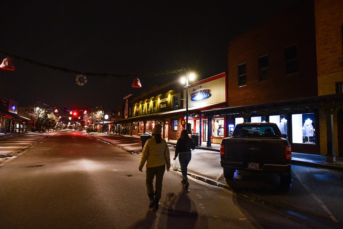 Carli Dewbre and Beth McBride, with the Montana Bar Fairies, walk downtown Whitefish in the earl mornings of Feb. 4, 2024. The pair are looking for cars that were left overnight in an effort to thank them, with a coffee card, for not drinking and driving. (Kate Heston/Daily Inter Lake)