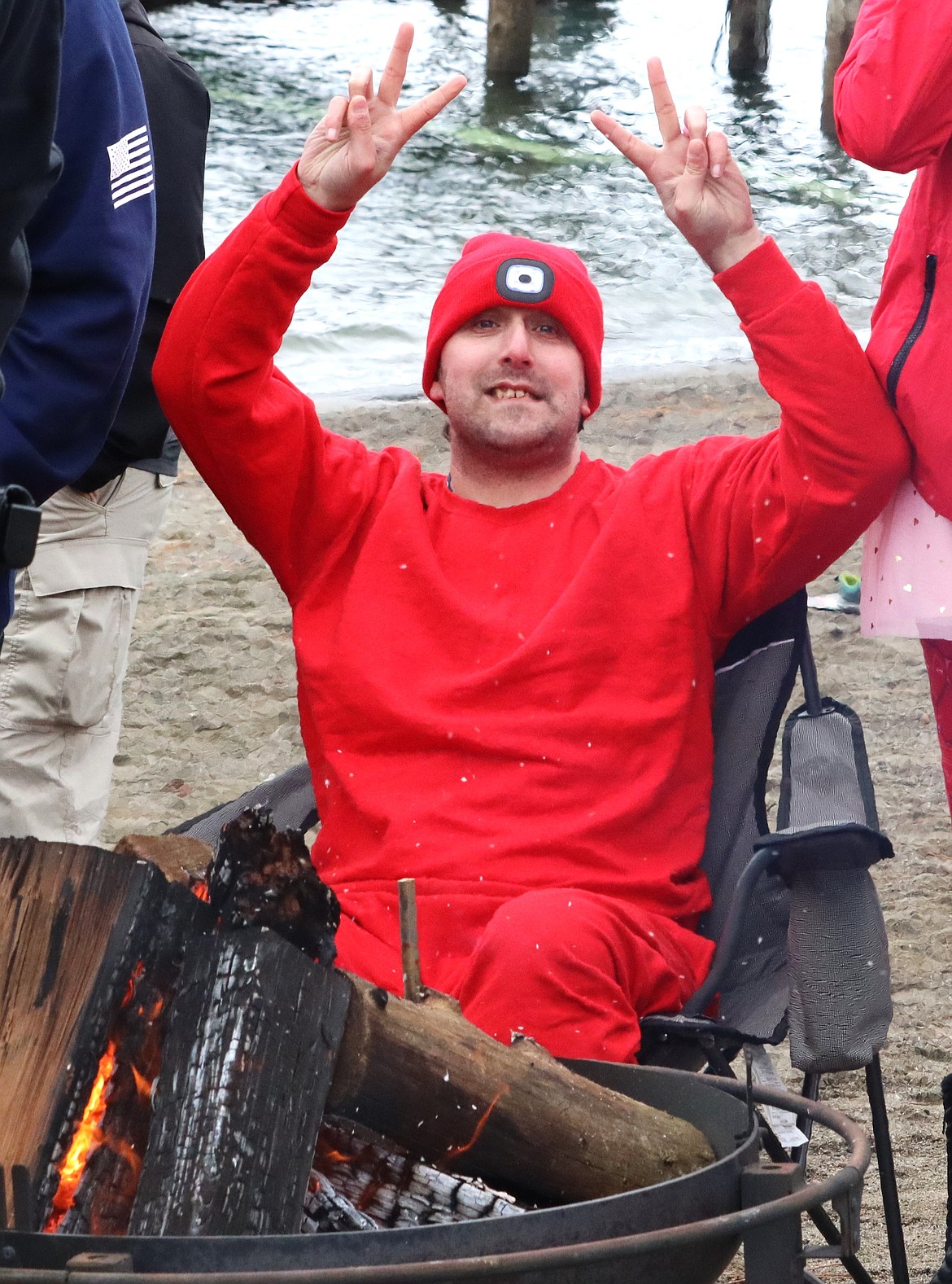 Dustin Johnson warms up by the fire after the Valentine's Polar Plunge into Lake Coeur d'Alene on Thursday.