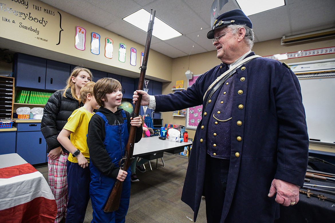 Civil War reenactor and historian Mike Inman gives students a chance to handle a musket in teacher Karissa Prewitt's class at Peterson Elementary School in Kalispell on Friday, Feb. 9. (Casey Kreider/Daily Inter Lake)