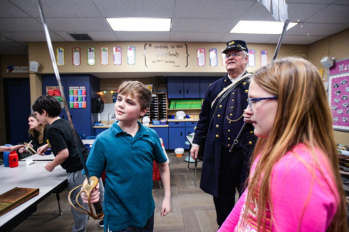 A student handles a Civil War-era saber during a lesson by reenactor and historian Mike Inman in fourth-grade teacher Karissa Prewitt's class at Peterson Elementary School in Kalispell on Friday, Feb. 9. (Casey Kreider/Daily Inter Lake)