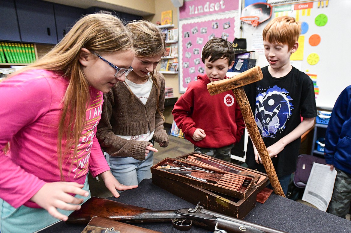 Fourth-grade students gather around a table of Civil War-era artifacts during a lesson by reenactor and historian Mike Inman in teacher Karissa Prewitt's class at Peterson Elementary School in Kalispell on Friday, Feb. 9. (Casey Kreider/Daily Inter Lake)