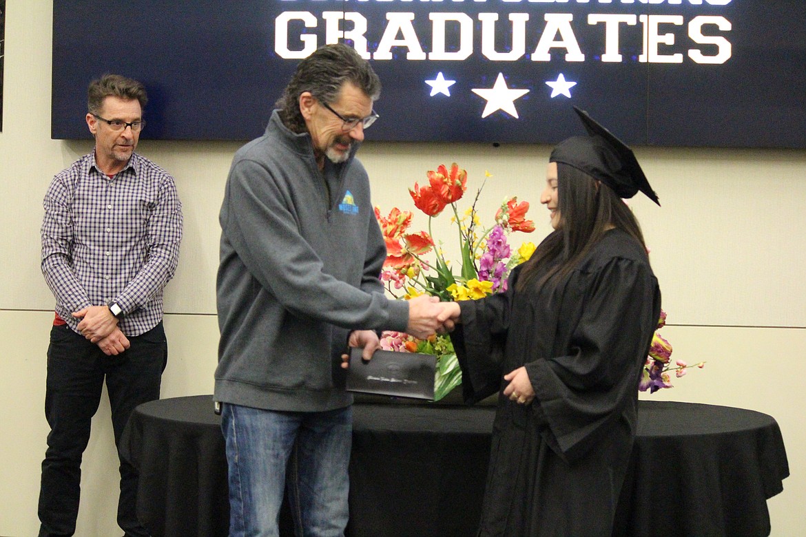 Melany Arias, right, receives her diploma from Moses Lake School Board member Paul Hill, left, at the Open Doors graduation ceremony Thursday.