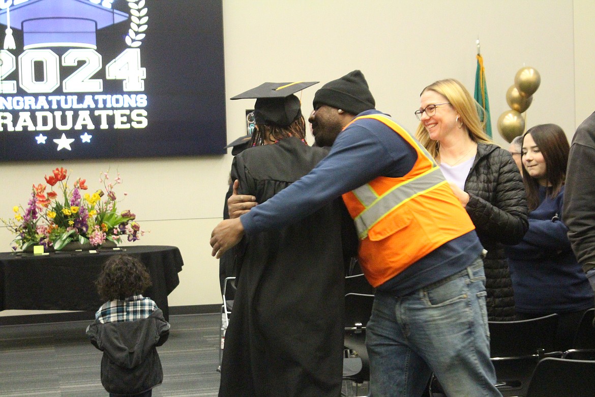 Open Doors graduate Monica Ford gets a hug from a family member during Thursday’s ceremony.