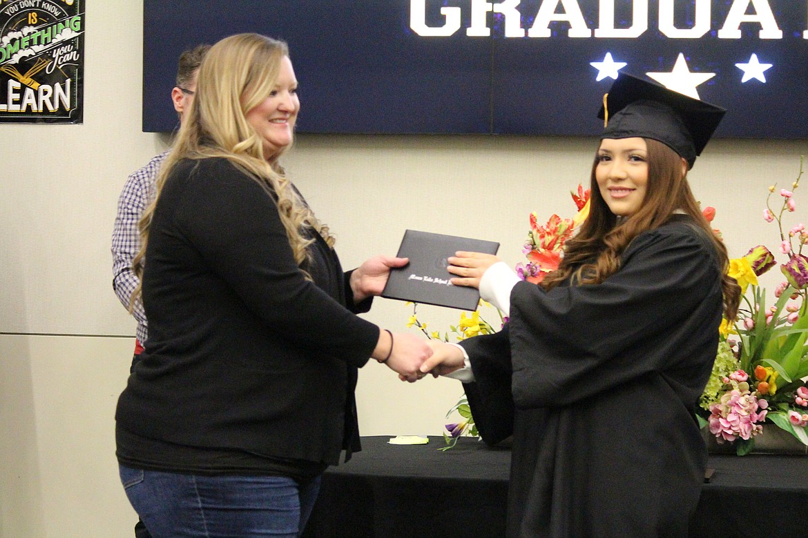 Moses Lake School Board member Kirryn Jensen, left, awards Jacqueline Becerra her diploma.