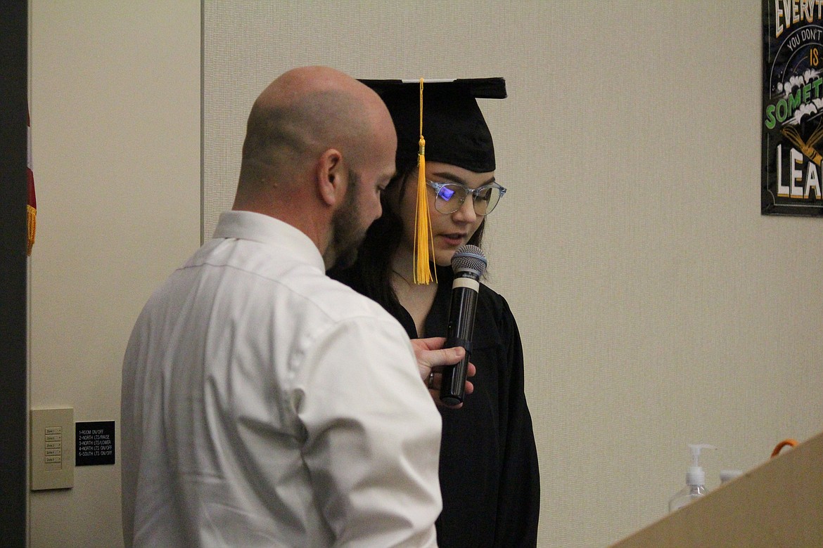 Kadence Spencer, right, tells her classmates they can change tassels at the end of Open Doors graduation ceremonies Thursday. Open Doors Administrator Brandon Byers holds the microphone.