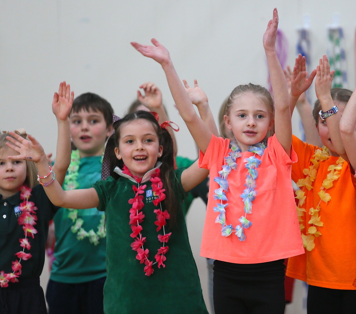 First grader Freya Burns, left, and second grader London Tierney participate in a "World Dance" performance during Sorensen's Friday Gathering. Students spent two weeks studying cultural dances with artist-in-residence Rachel Horner.